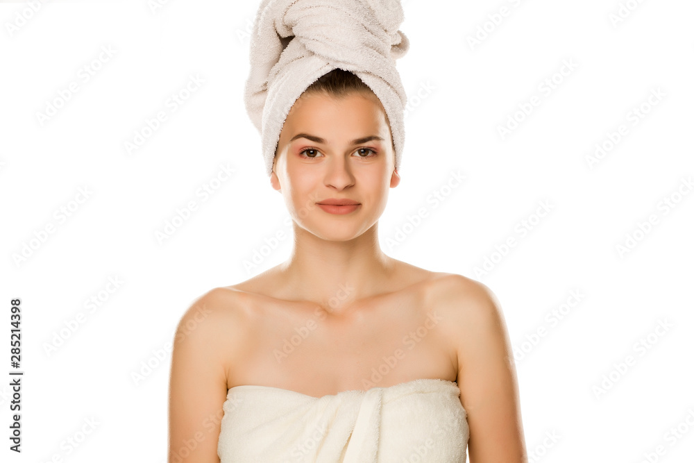 Portrait of young smiling beautiful woman with towel on her head on white background Portrait of young smiling beautiful woman with towel on her head on white background