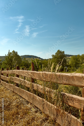 Fototapeta Naklejka Na Ścianę i Meble -  Close view on old wooden fence in a countryside in a summer time with clear sky