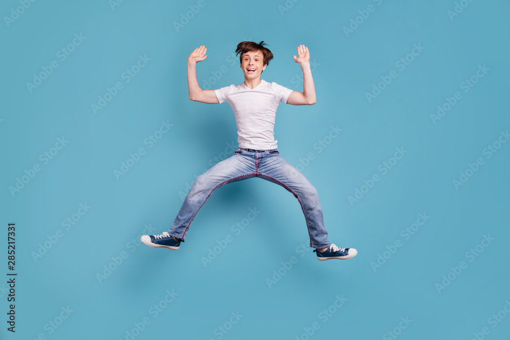 Full length body size photo of boy preparing to do splits right in air while isolated with blue background