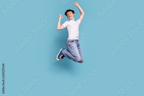 Full length body size photo of overjoyed rejoicing champion having won contests at soccer with his team while isolated with blue background