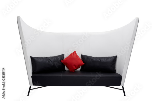 Modern leather sofa with white and black elements and red pillow