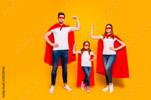 Family of three members playing cartoon incredible characters wear superhero costume isolated yellow background