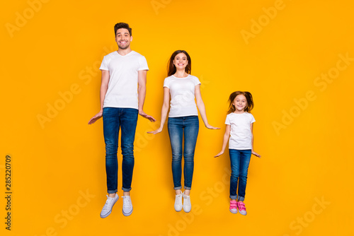 Full length body size view of three nice attractive slim fit sporty healthy cheerful cheery person having fun jumping up holiday isolated over bright vivid shine yellow background