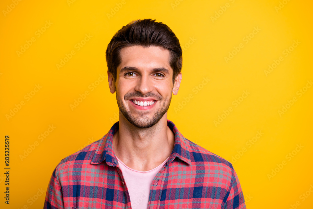 Portrait of young smiling cheerful man caring about nothing while isolated with yellow background Portrait of young smiling cheerful man caring about nothing while isolated with yellow background