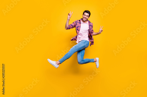 Full length body size photo of man running on air showing you v-sign in order to say hi while isolated with yellow background