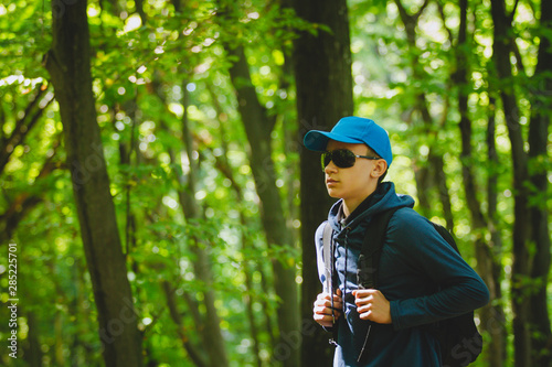 Fototapeta Naklejka Na Ścianę i Meble -  Traveler guy walks through the woods