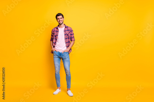 Full length body size photo of enjoying guy posing in front of camera while isolated with yellow background