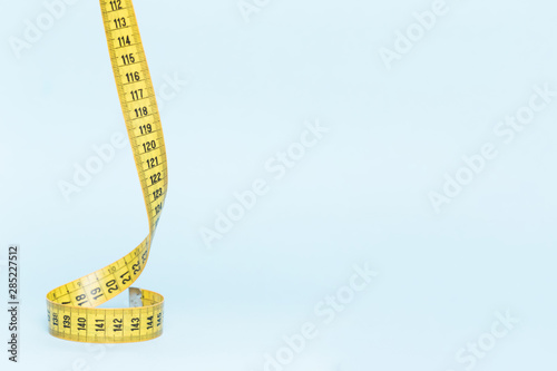 Yellow tape measure on blue background