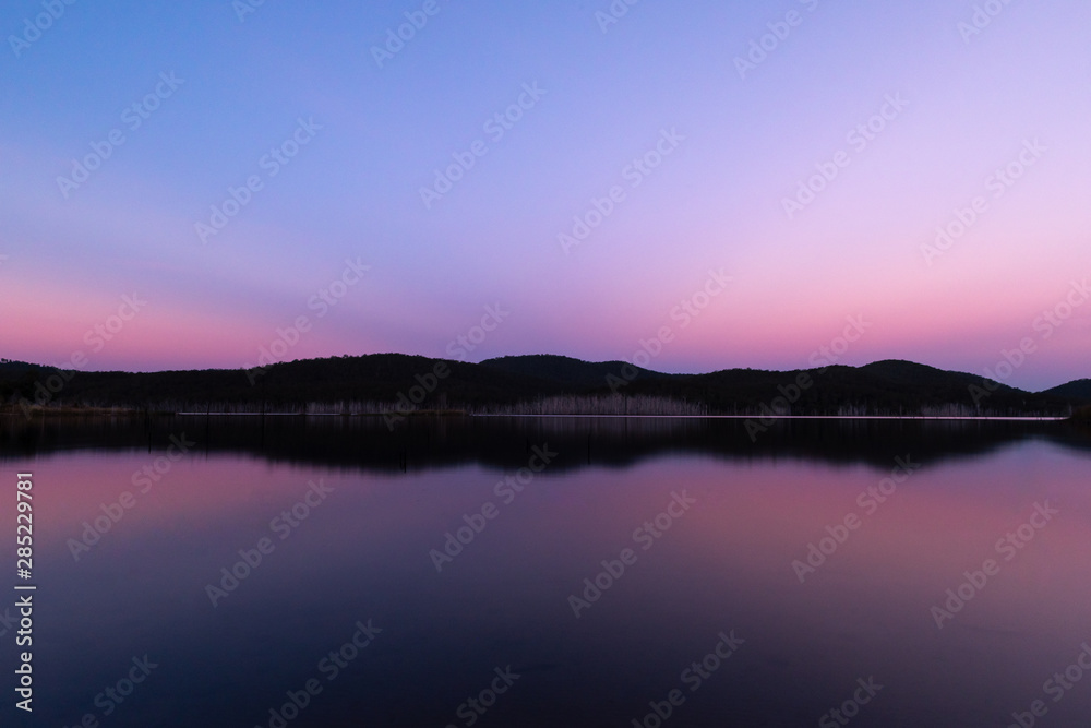 A perfect reflection during a pink sunset a lake on a clear and sunny day in Queensland, Australia