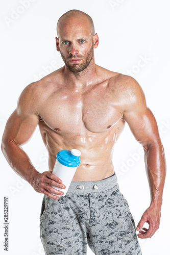 Strong bodybuilder holding a classic fitness shaker Isolated on white background in studio Concept sports nutrition