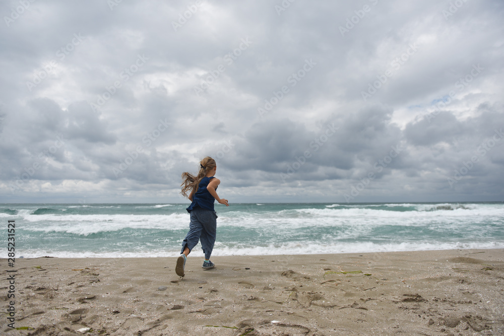 girl running on the sandy beach by the sea girl running on the sandy beach by the sea