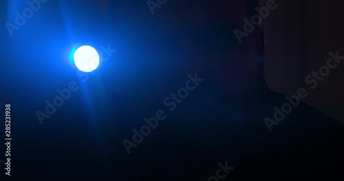 The man with a flashlight walking on the road. night time. anamorphic lens shot closeup, 4k