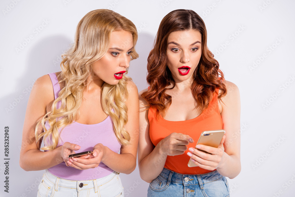 Pretty ladies holding telephones hands read bad news wear casual tank-tops isolated white background