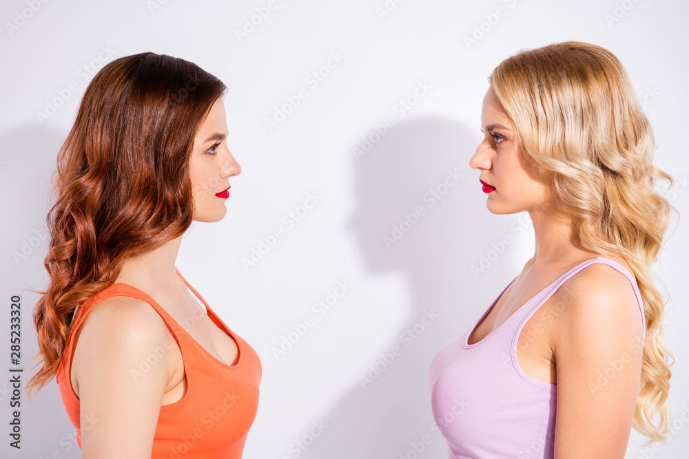 Close-up profile side view portrait of two nice attractive shine charming cute lovely pretty winsome content wavy-haired ladies looking at each other isolated over white light background Close-up profile side view portrait of two nice attractive shine charming cute lovely pretty winsome content wavy-haired ladies looking at each other isolated over white light background