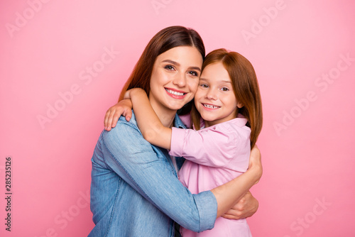 Portrait of charming people cuddling with beaming smiles wearing denim jeans shirt isolated over pink background