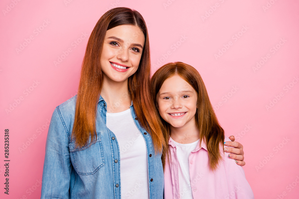 Portrait of two sweet girls hugging with toothy smile isolated over pink background Portrait of two sweet girls hugging with toothy smile isolated over pink background
