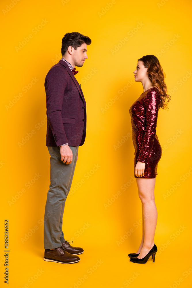 Vertical full length body size profile side view of nice attractive gorgeous content calm candid serious gentleman lady looking at each other isolated over bright vivid shine yellow background Vertical full length body size profile side view of nice attractive gorgeous content calm candid serious gentleman lady looking at each other isolated over bright vivid shine yellow background