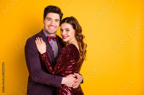 Portrait of his he her she nice-looking attractive lovely smart charming pretty cheerful gentle people cuddling spending festive isolated over bright vivid shine yellow background