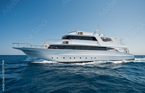 Luxury motor yacht sailing out on tropcial sea © Paul Vinten