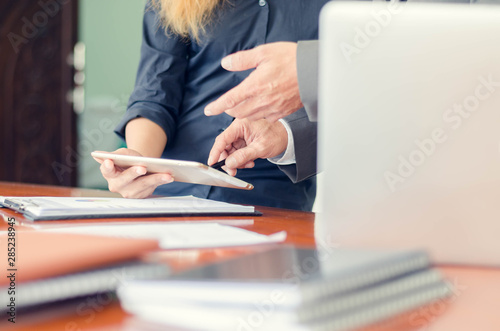 Business managers using pen pointing to tablet discussion information projects with young woman at office
