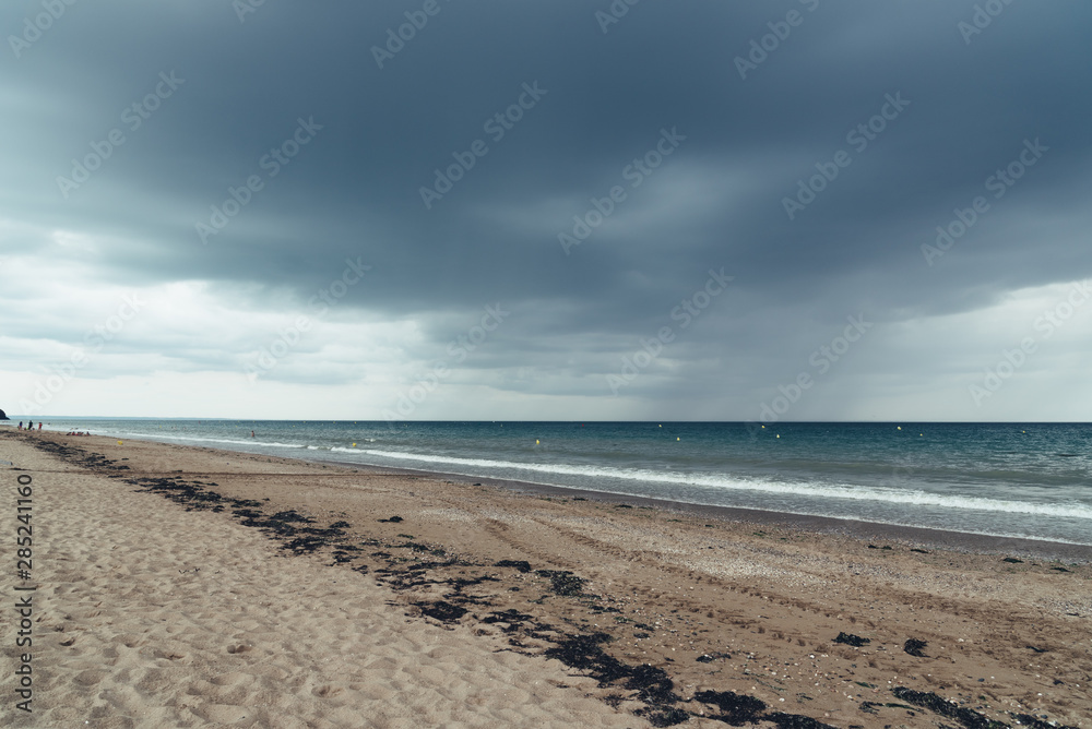 Beach with dark clouds and incoming rain storm