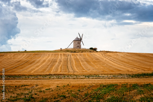 Windmill on a hill against cloudy sky
