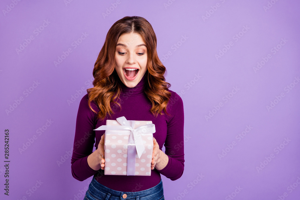 Portrait of crazy lovely girl hold hand giftbox look shout isolated over violet purple background Portrait of crazy lovely girl hold hand giftbox look shout isolated over violet purple background