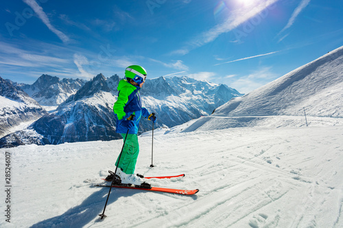 Boy portrait on snow slope over mountain peaks