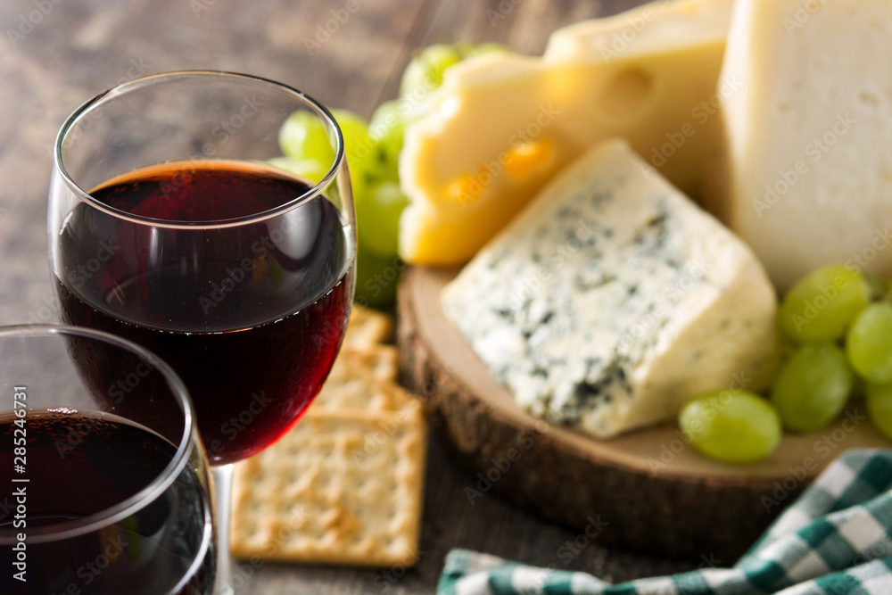 Assortment of cheeses and wine on wooden table. Assortment of cheeses and wine on wooden table.