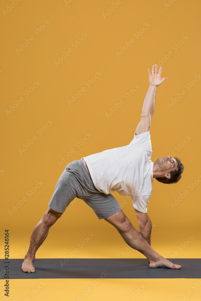 Athletic man exercising on yoga mat