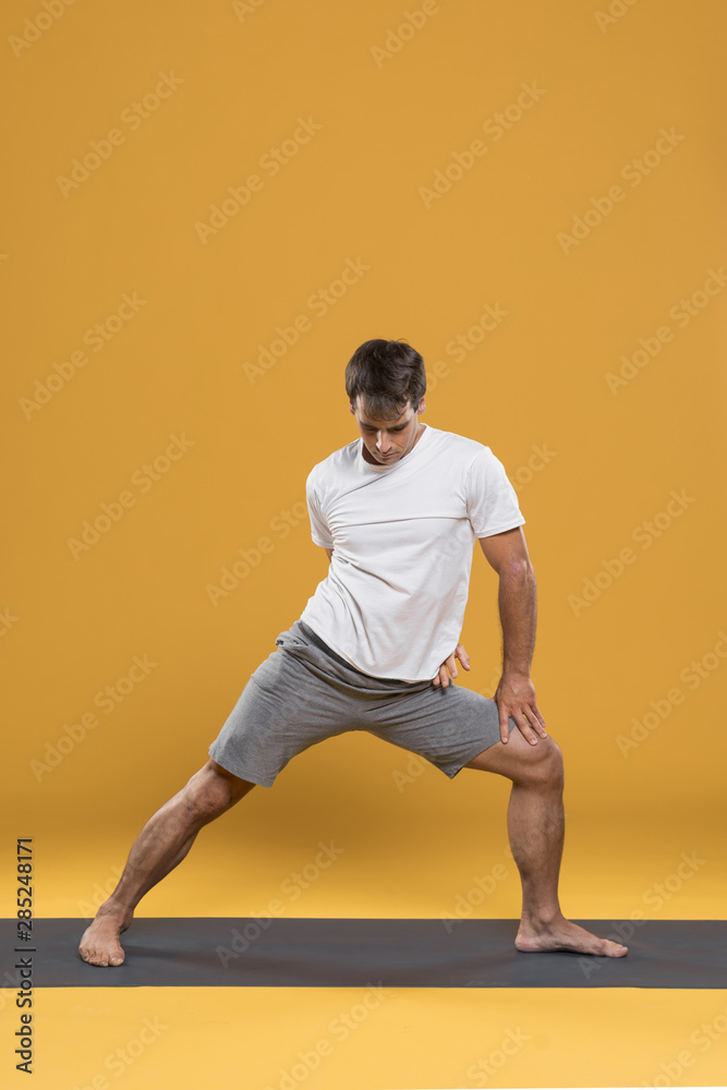 Athletic man stretching on yoga mat