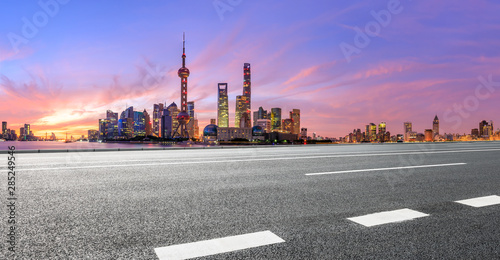 Shanghai skyline and modern buildings with empty asphalt highway at sunrise panoramic view.