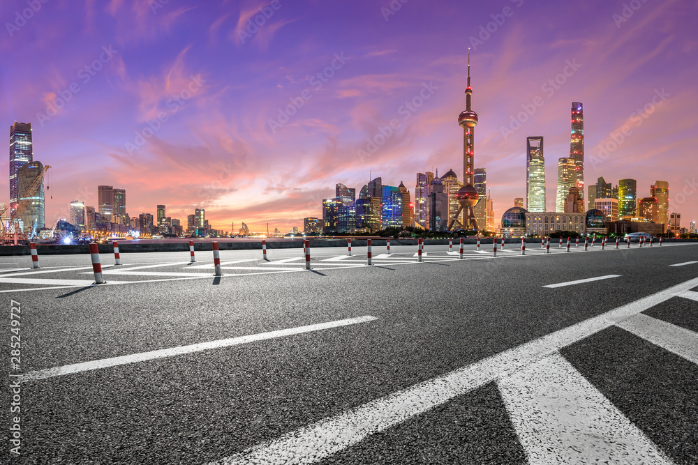 Shanghai skyline and modern buildings with empty asphalt highway at sunrise,China