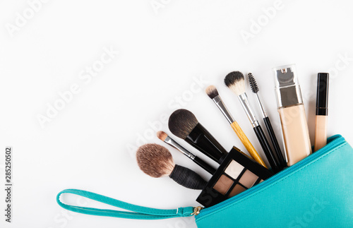 Set of woman's cosmetics in a bag. Women's secrets. Cosmetics, perfume, brushes, powder, highlighter, concealer,patelle with eye shadows. female cosmetics bag on white background. Make up. Copy space