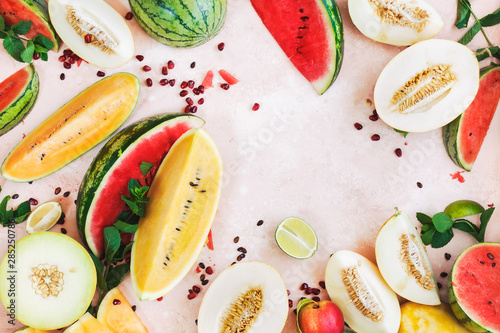 Assorted types of watermelons, melons , pomegranate and peaches, top view, copy space