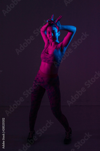 Portrait of a young dancer in bright color light in the Studio