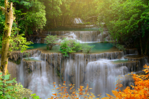 Beautiful waterfall in tropical forest with warm sunshine.