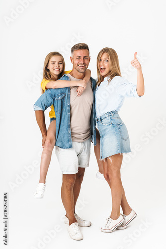 Full length photo of cheery caucasian family woman and man with little girl smiling and showing thumb up