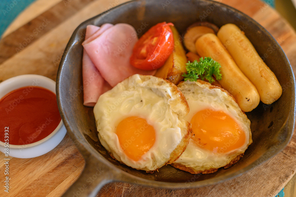 English breakfast in pan with fried eggs  sausages