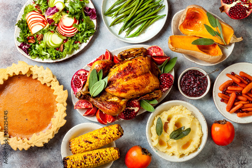 Foto Thanksgiving dinner table with roasted whole chicken or turkey, green beans, mashed potatoes, cranberry sauce and grilled autumn vegetables
