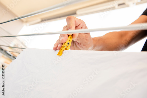 man hanging clothes on a drying rack. photo