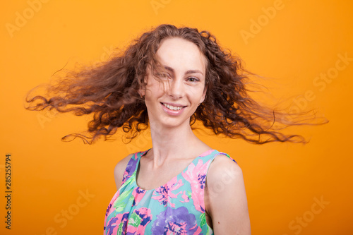 Gorgeous caucasian womam shaking her hair over orange background photo