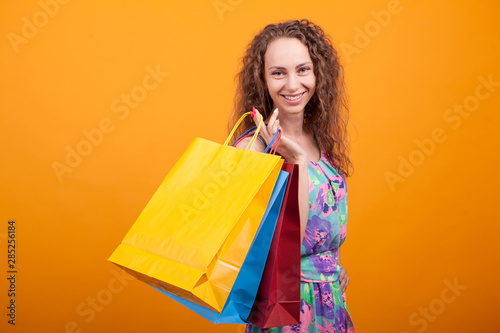 Stylish caucasian woman smiling and holding shopping bags