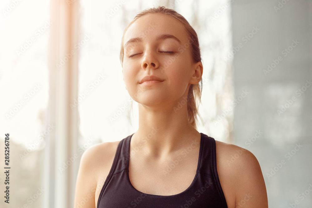 Sporty woman meditating with closed eyes
