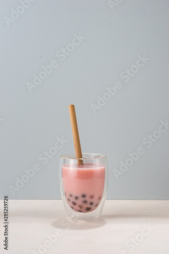 Refreshing homemade iced milky bubble tea with tapioca pearls. Strawberry and raspberry bubble tea on spring background.