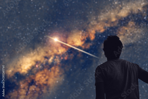 Man observing the night sky and Milky way with a shooting star trail. My astronomy work.