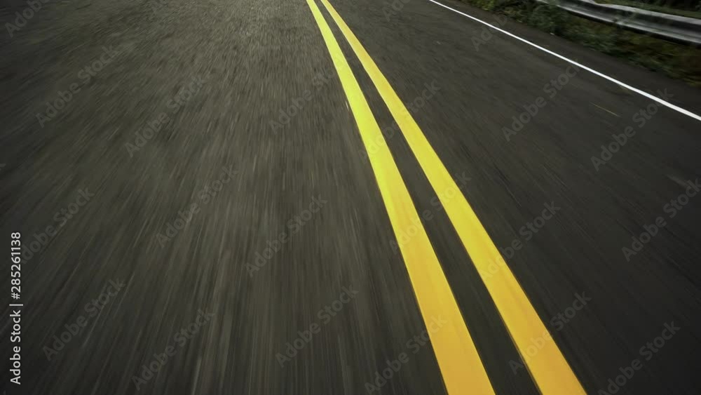 Front pov view of fast car driving on asphalt road