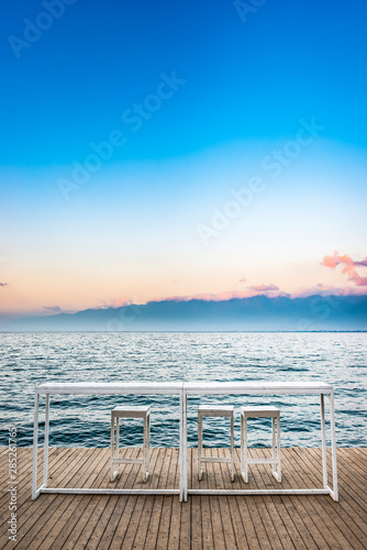 White table and chairs against the blue lake. Located in Erhai Lake  Dali  Yunnan  China.