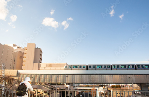 Odaiba, Japan - 13 DEC 2017: Asian tourist with his camera trying to snap the local Japanese skytrain at Odaiba that is the man made island in Tokyo bay. photo