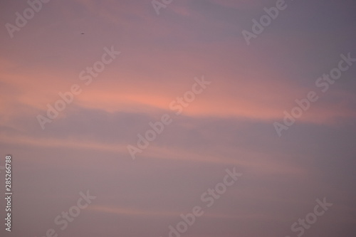 Light orange colored sky with visible clouds during a sunset